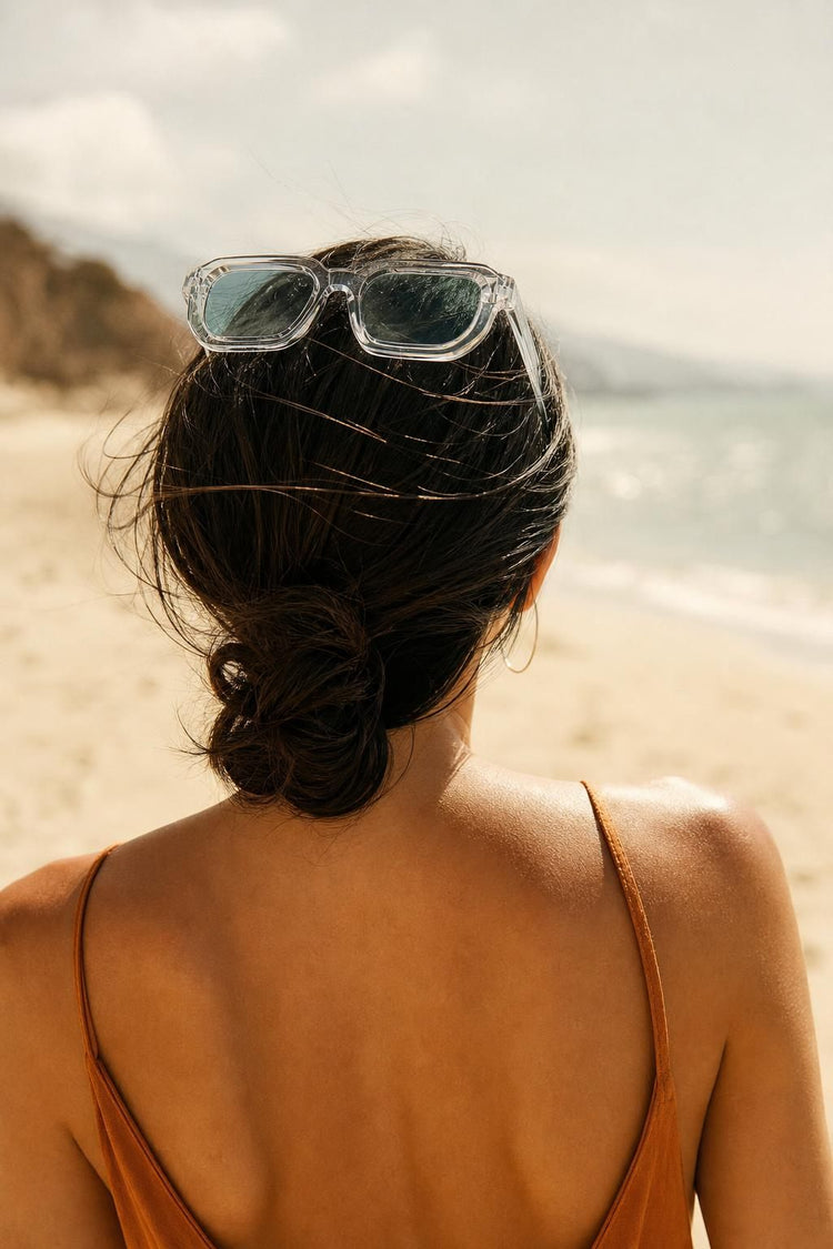 Gafas de sol de montura transparente y lente agua en la playa